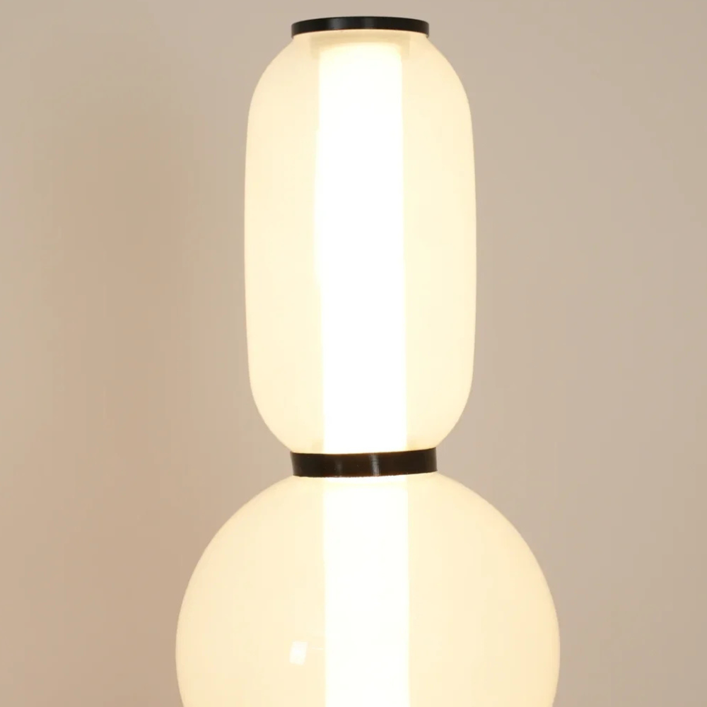 Moderne LED-Stehlampe mit gestapelten mundgeblasenen Glassteinchen und schlankem Metallstab